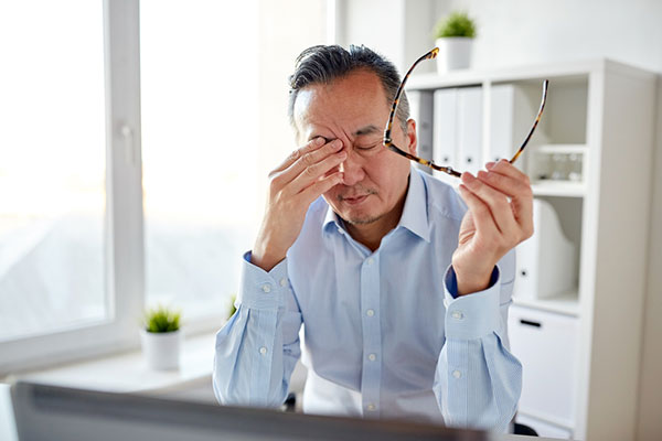 Man rubbing his eyes because of dry eyes