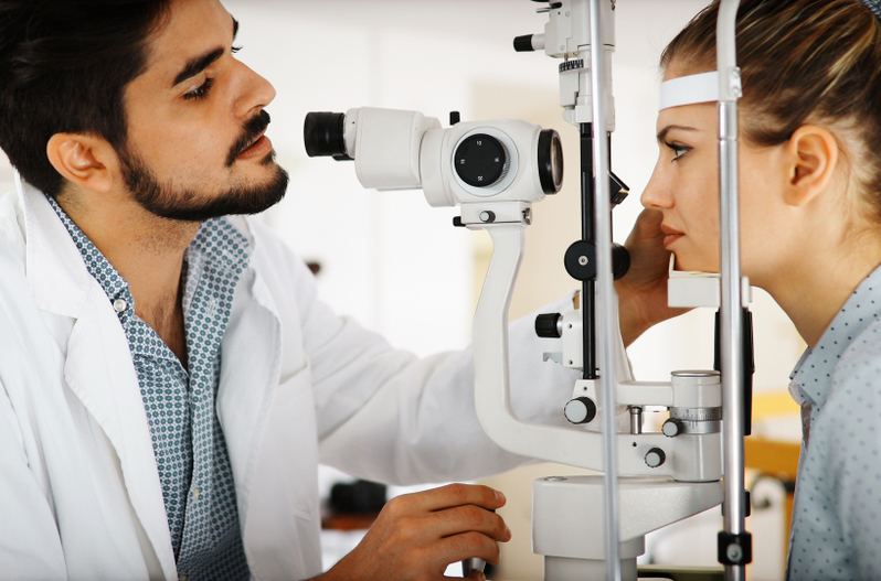 Optometrist conducting an eye exam on a young man