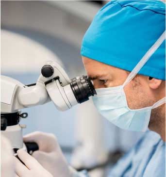 A doctor examines something through a microscope